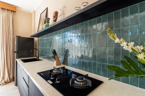 eine Küche mit grün gefliester Wand und Herd in der Unterkunft Stylish New Suites with Pool Near Balangan Beach in Bingin Beach