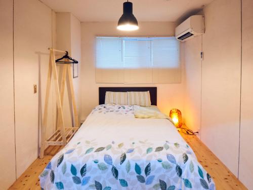 a bedroom with a bed in a room with a window at Guesthouse Banvina in Kagoshima