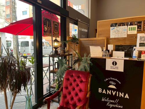 a restaurant with a red chair in front of a window at Guesthouse Banvina in Kagoshima