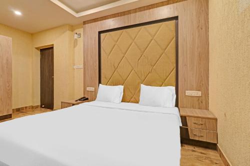 um quarto com uma cama grande e um espelho grande em Hotel O Grand Karaikudi em Tiruchchirappalli
