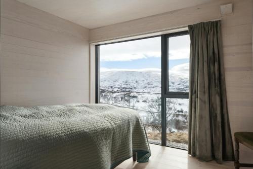 ein Schlafzimmer mit einem Bett und einem großen Fenster in der Unterkunft New Cabin With Panoramic Views At Hardangervidda in Maurset