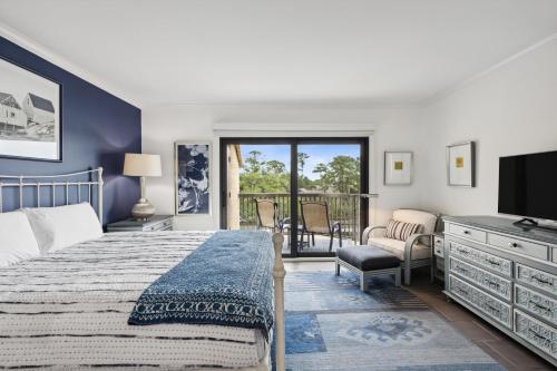 a bedroom with a bed and a television and a balcony at 236 Captains Quarters in Hilton Head Island