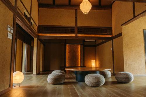 a room with a table and some stools at 囲み宿 こわね in Tonosho