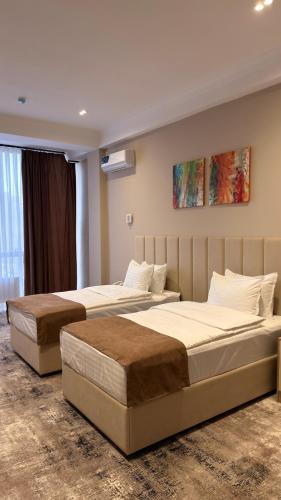 two beds in a hotel room with two beds at SUVON Hotel in Stantsiya Kyzyl-Tukumachi