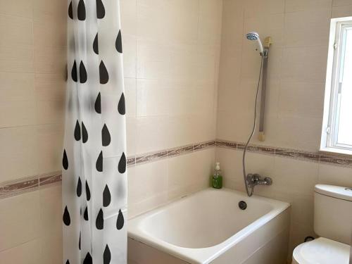 Un baño con cortina de ducha y bañera. en Man Va Hotel, en Macau