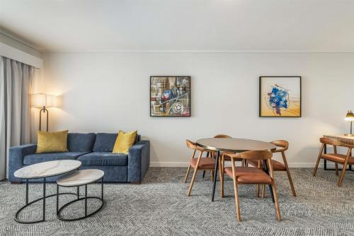 a living room with a couch and a table and chairs at Adina Apartment Hotel Perth Barrack Plaza in Perth