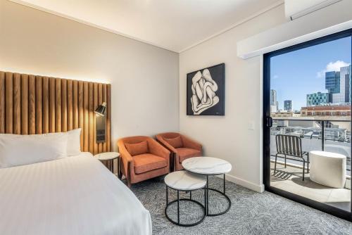 Una habitación de hotel con una cama, una silla y una ventana. en Adina Apartment Hotel Perth Barrack Plaza, en Perth