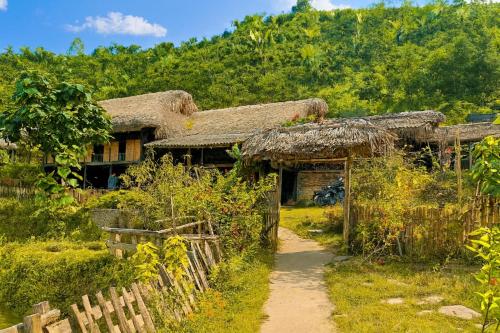 an old house with a thatched roof and a path at Bình Bản Liền Homestay - Vang A Binh in Bắc Hà