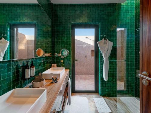 a green tiled bathroom with a sink and a shower at Fairmont Royal Palm Marrakech in Marrakech