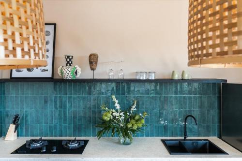 eine Küchentheke mit einer Spüle und einer Vase aus Blumen in der Unterkunft Brand-New Suites with Pool Minutes from Beach in Bingin Beach