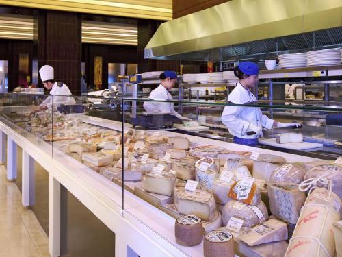 a group of chefs preparing food in a kitchen at La Cigale Hotel Managed by Accor in Doha