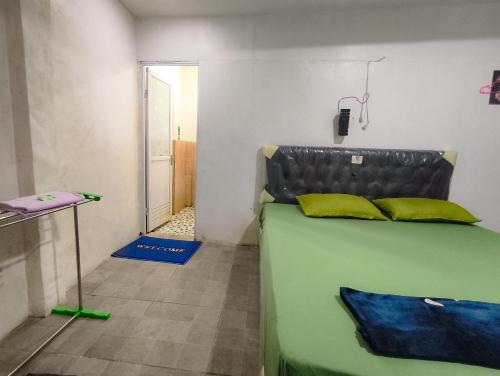 a room with a bed with yellow pillows on it at Loox Hotel Grand Aroya in Mataram