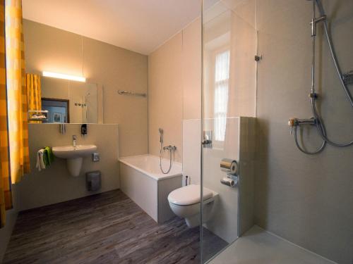 a bathroom with a toilet and a sink and a shower at Altstadt-Hotel in Amberg