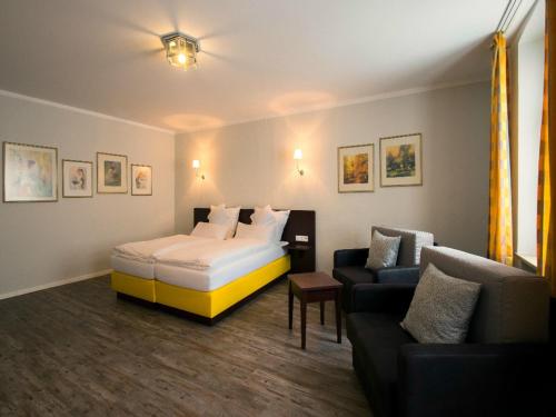 um quarto de hotel com uma cama e um sofá em Altstadt-Hotel em Amberg