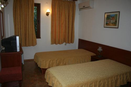 a hotel room with two beds and a television at Todorova House in Zlatograd
