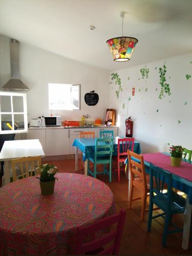 a kitchen and dining room with colorful tables and chairs at Hostel Raymundo in Évora