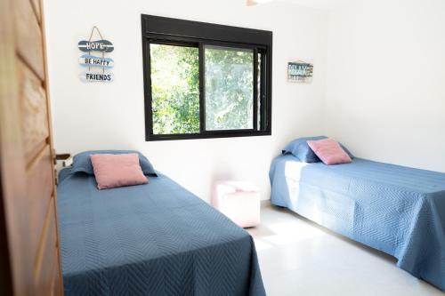 zwei Betten in einem Zimmer mit Fenster in der Unterkunft Casaboa Paúba in São Sebastião