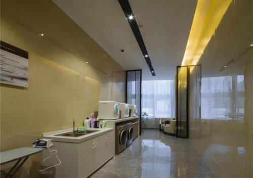 una cocina con fregadero y lavadora en Echeng Hotel Changsha Evening News, en Changsha