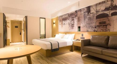 a hotel room with a bed and a couch at City Comfort Inn Nanning Kede Zoo Qingchuan Metro Station in Nanning