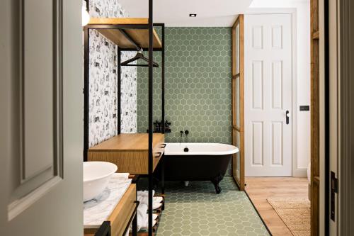 a bathroom with a black tub and green tiles at Quinta de S.Bernardo - Winery & Farmhouse in Mesão Frio