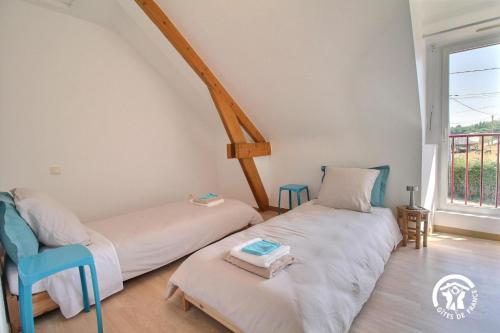 two beds in a room with a window at Les roses tremieres in Nivillac