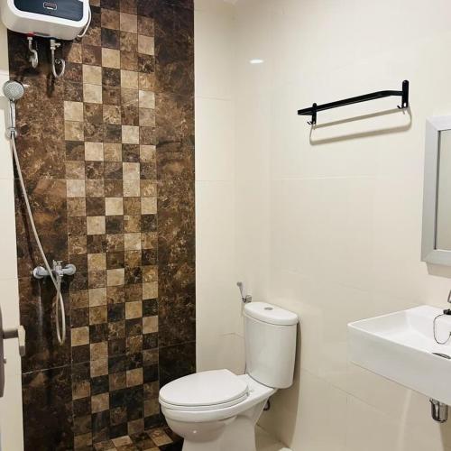 a bathroom with a toilet and a sink and a shower at Wisma teluk bayur sidapore Tb in Lamobuang