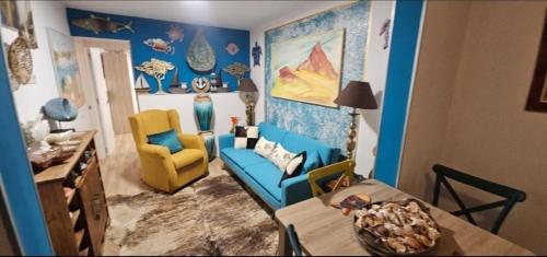 un salon avec un canapé bleu et un fauteuil jaune dans l'établissement Descanso cerca del mar, à Las Galletas