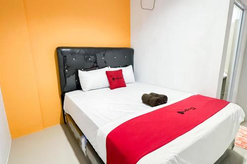 een slaapkamer met een groot bed met een rode deken bij RedDoorz at Batam Center 3 in Pulau Sembakau Kecil
