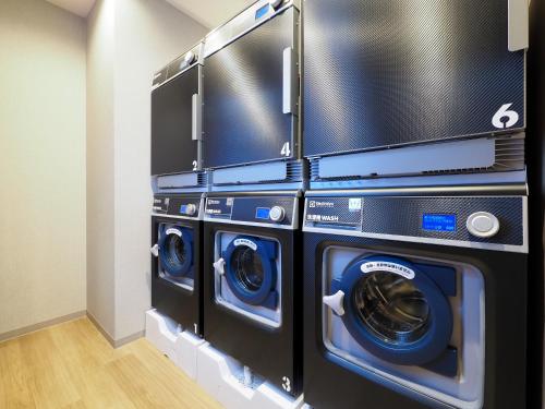 Bannaguroにあるたびのホテル石狩の洗濯室にある洗濯機と乾燥機の3台