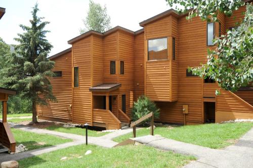a house with a wooden facade in a yard at Aspen Ridge Condominiums by Keystone Resort in Keystone