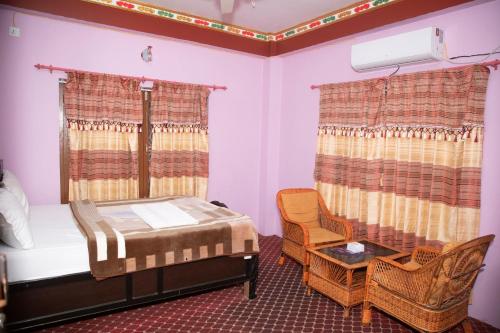 a bedroom with a bed and a table and a chair at Hotel Sauraha Gaida House in Chitwan