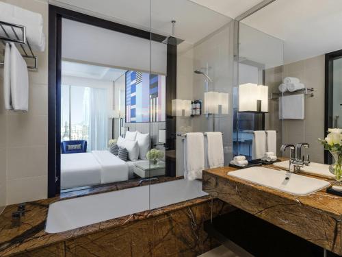 a bathroom with a sink and a large mirror at Pullman Dubai Downtown in Dubai