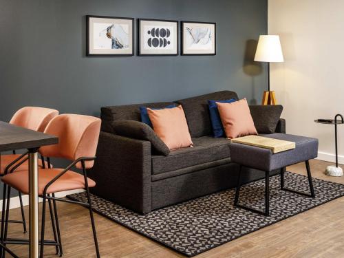 a living room with a couch and a table at Aparthotel Adagio London Sutton Point in Sutton