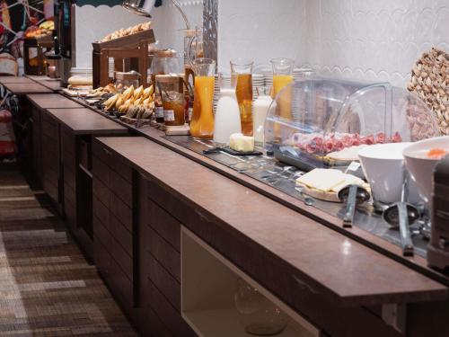 Una línea de buffet con comida y bebidas. en ibis Styles Thonon-les-Bains, en Thonon-les-Bains
