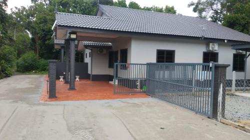 a house with a gate and a driveway at ABG JEFF HOMESTAYs in Bukit Payong