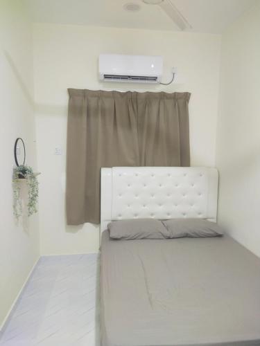 a white bed in a room with a window at ABG JEFF HOMESTAYs in Bukit Payong