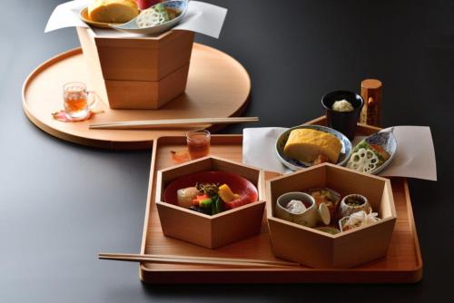 two plates of food on a wooden tray at Shima Onsen Yoshimoto in Nakanojo