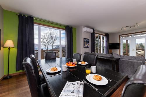 a dining room with a table with plates of food at Condo 120B, Hot Tub, Panoramic Views & Game Area in Petite-Rivière-Saint-François