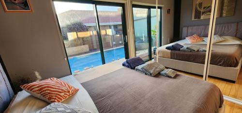 a bedroom with two beds and a swimming pool at Coorong GateAway POOL - SPA - SAUNA in Hindmarsh Island
