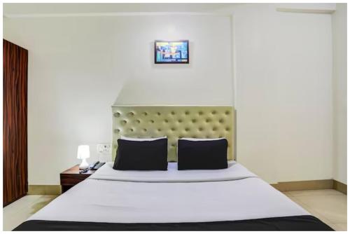 a bedroom with a large bed with a green headboard at HOTEL TRIPLE -TREE Near Railway Station - Fully Air Conditioning- Best In Bhubneshwar Hotel in Cuttack