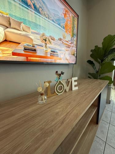 a living room with a love sign on a table at Charming Hideaway in Sandton