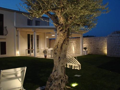 un árbol en un patio al lado de una casa en Kinanto Bioresort en Ispica