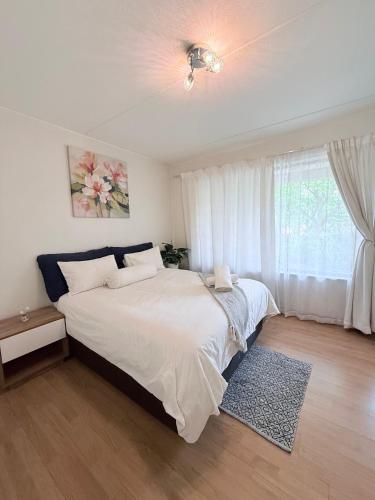 a bedroom with a large bed and a window at Charming Hideaway in Sandton