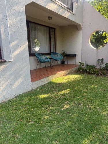 a house with two chairs and a table on a porch at Charming Hideaway in Sandton