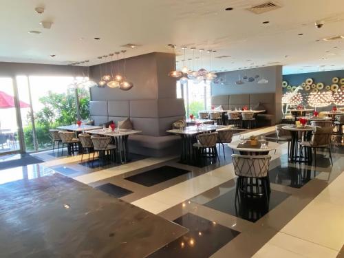 a dining room with tables and chairs in a restaurant at The Hotel Residences at Acqua in Manila