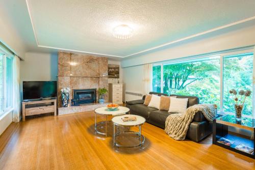 a living room with a couch and a fireplace at South Vancouver Garden Home in Vancouver