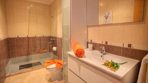 ein Bad mit einem Waschbecken, einem WC und einer Dusche in der Unterkunft Apartamento Los Lagos del Cotillo in Cotillo