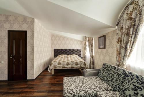 a living room with a couch and a bed at Hotel Gold in Volgograd