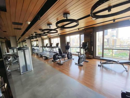 a gym with a row of treadmills and ellipticals at The Hotel Residences at Acqua in Manila