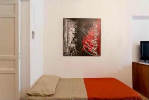 - une chambre avec un lit et une peinture murale dans l'établissement Casetta in centro, à Palerme